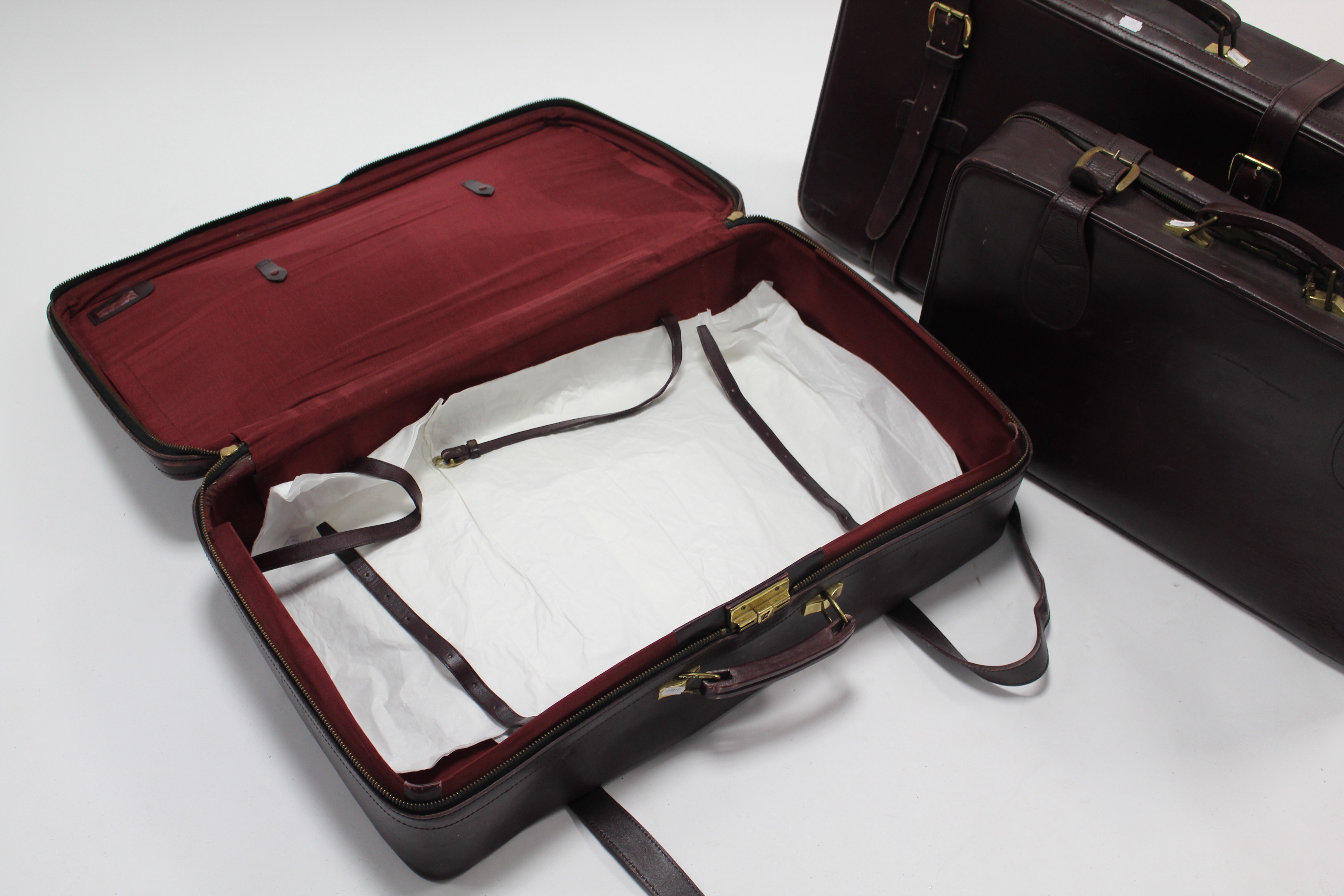 A set of three crimson fibre-covered graduated suitcases. - Image 3 of 3