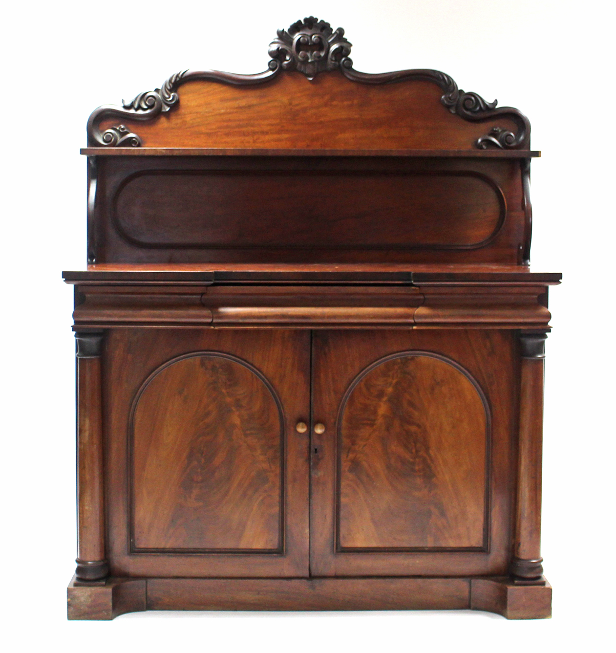 A Victorian mahogany inverted break-front chiffonier with open shelf to the shaped panel back,