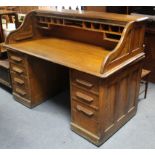 A late 19th/early 20th century oak roll-top desk, with fitted interior enclosed by tambour