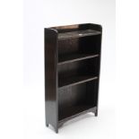 An Edwardian oak small standing open bookcase with three adjustable shelves, & with shaped end