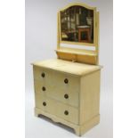 A cream painted pine small dressing chest with rectangular swing mirror to the stage back, fitted