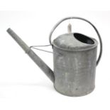 A galvanised-metal watering can, 15” high.