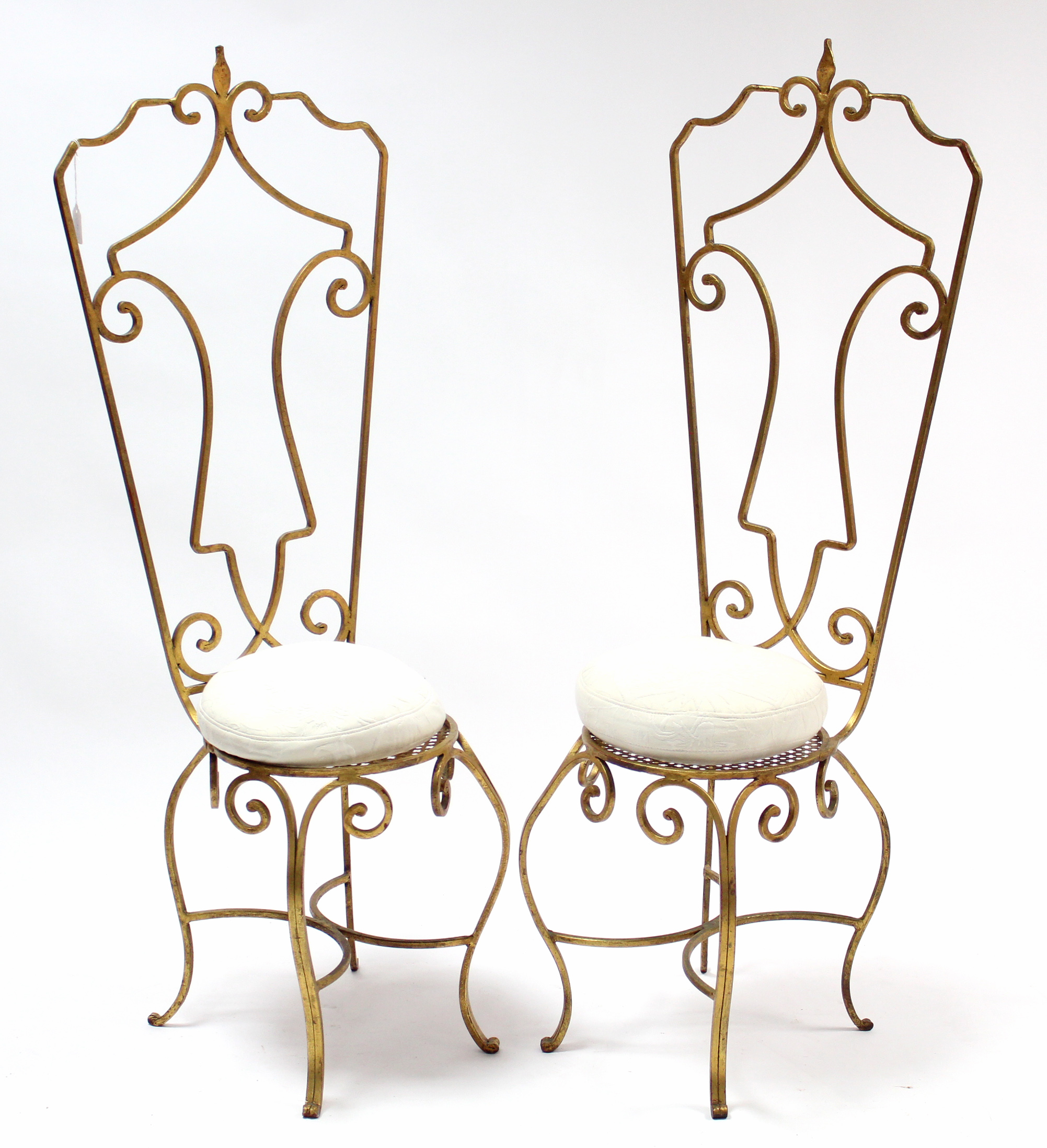 A pair of gold painted wrought-iron occasional chairs with tall open backs, circular seats, & on