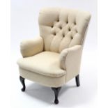 A Georgian-style buttoned-back armchair upholstered cream material, & on short cabriole legs & pad