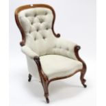 A mid-Victorian carved beech-frame buttoned-back armchair upholstered cream geometric material, & on
