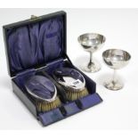 A pair of George V silver-backed hair brushes, Birmingham 1924, cased; & a pair of silver goblets,