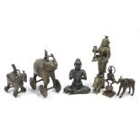 An Indian cast bronze figure of a deity standing on the back of an elephant & holding a shallow