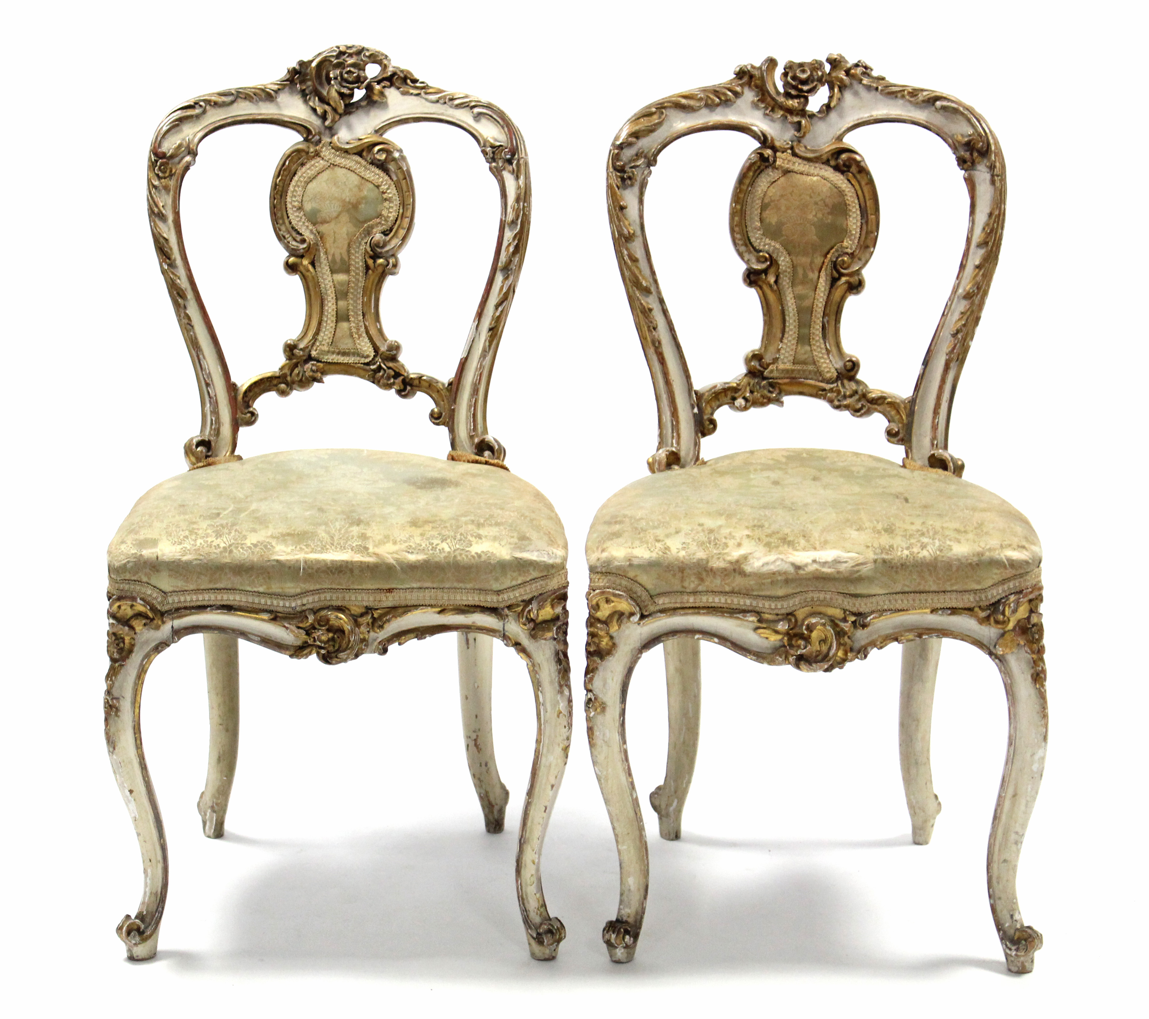 A pair of 19th century French cream & gilt painted salon chairs with rococo-style foliate carving,