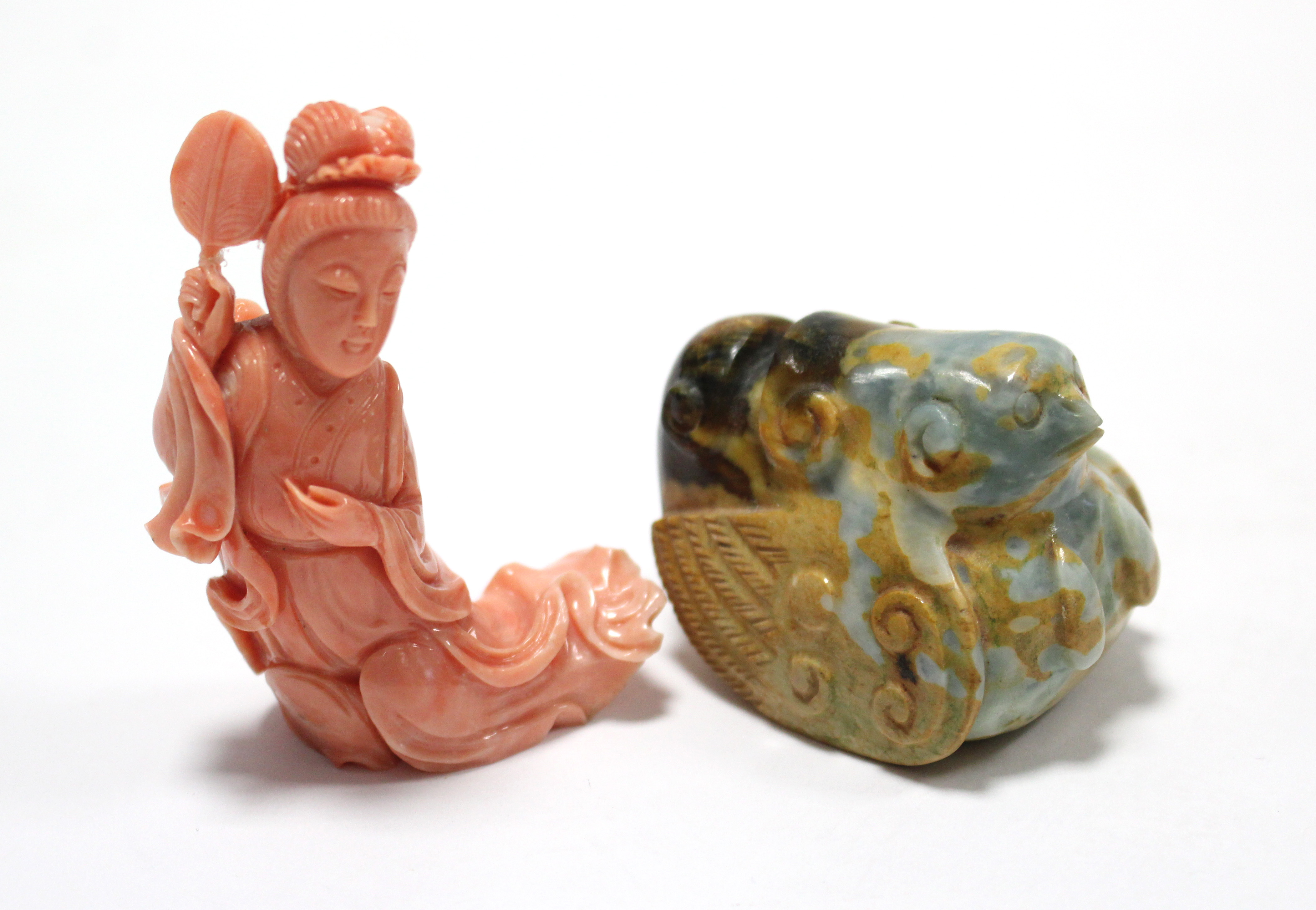 A Chinese carved pink coral reclining female figure holding a fan, 2?” high (fan re-stuck); & a