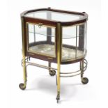 An Edwardian mahogany & brass-mounted trolley with glazed top & sides, fitted single shelf, on brass