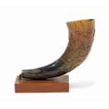 A Chinese carved buffalo horn decorated in low relief with an encircling dragon & scrolling