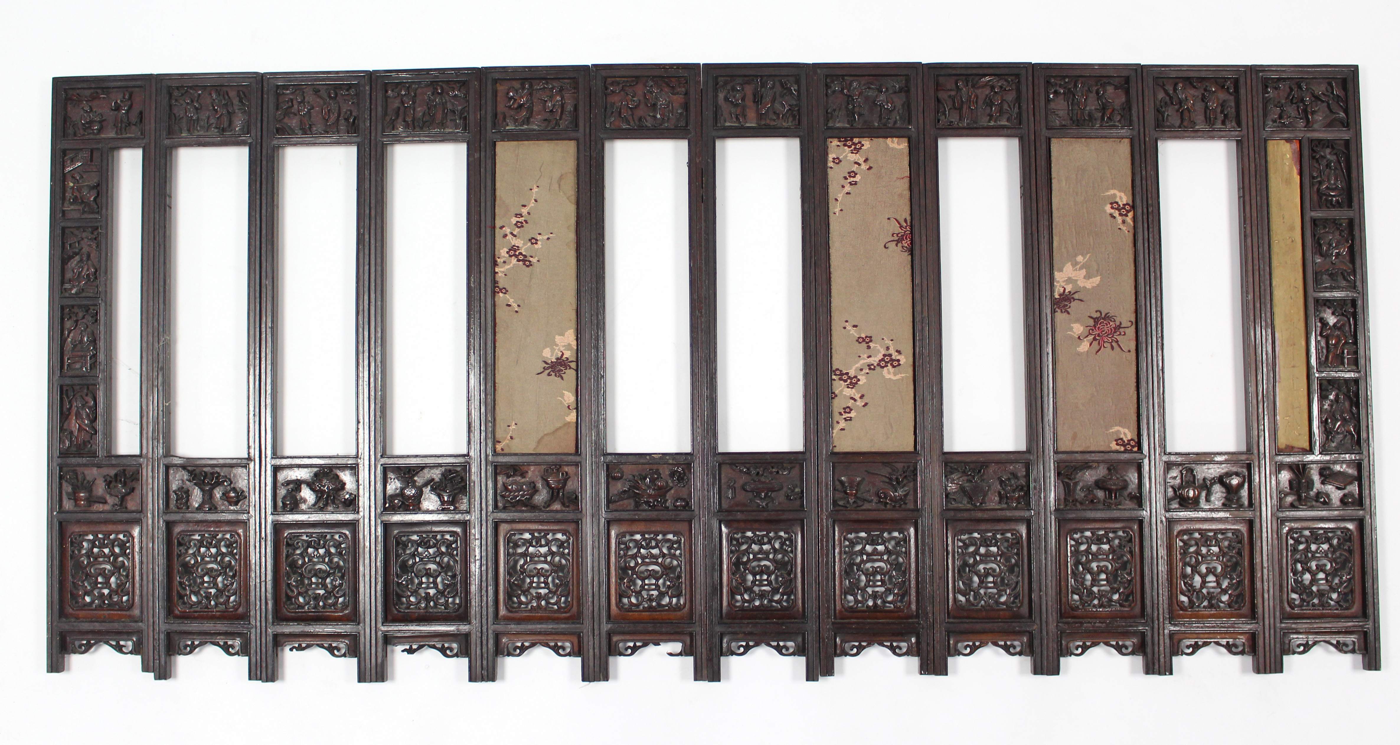 An early 20th century Chinese carved hardwood screen decorated with precious objects, figures, &