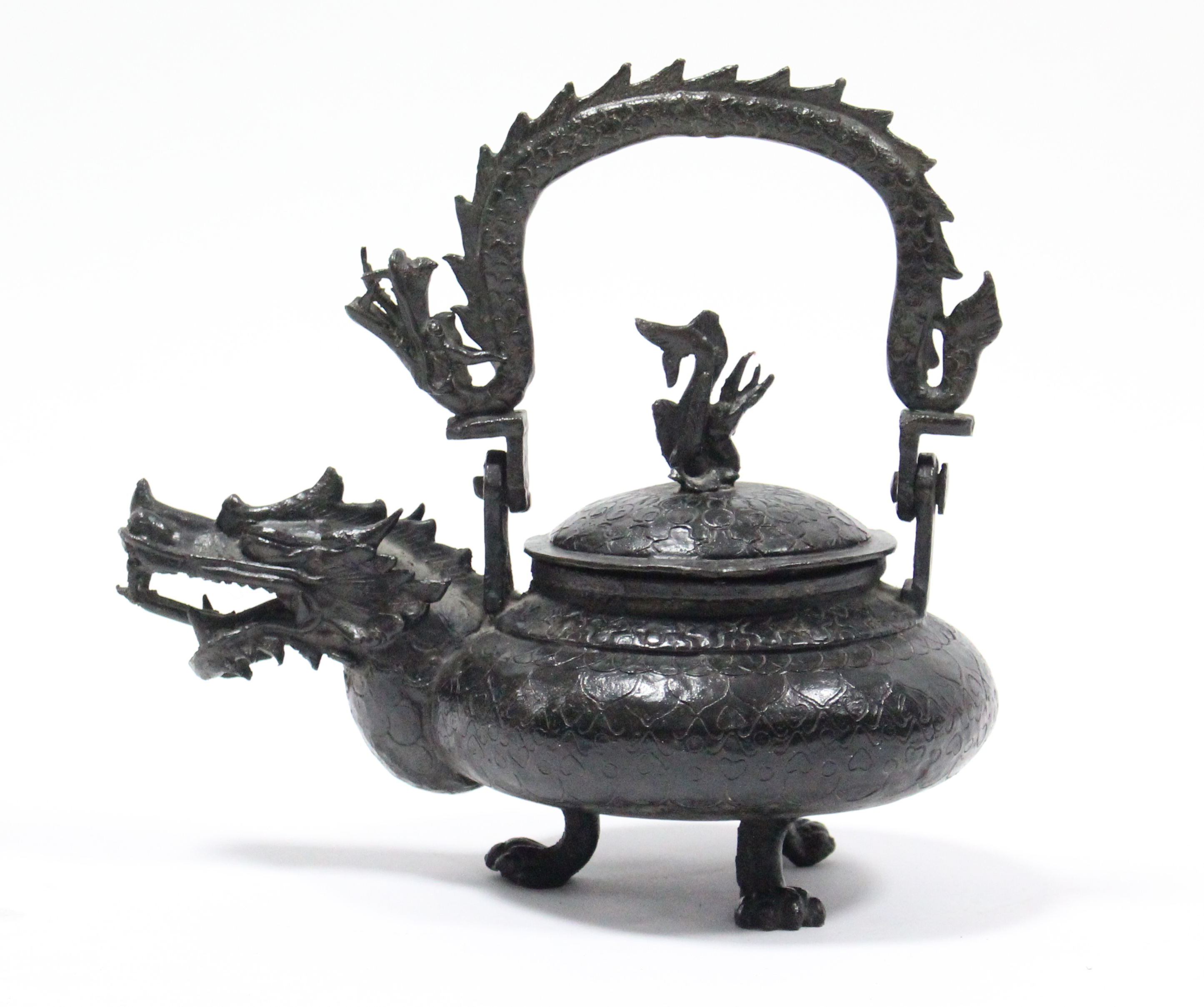 A late 19th century Chinese bronze teapot with squat round body, dragon spout & swing handle in