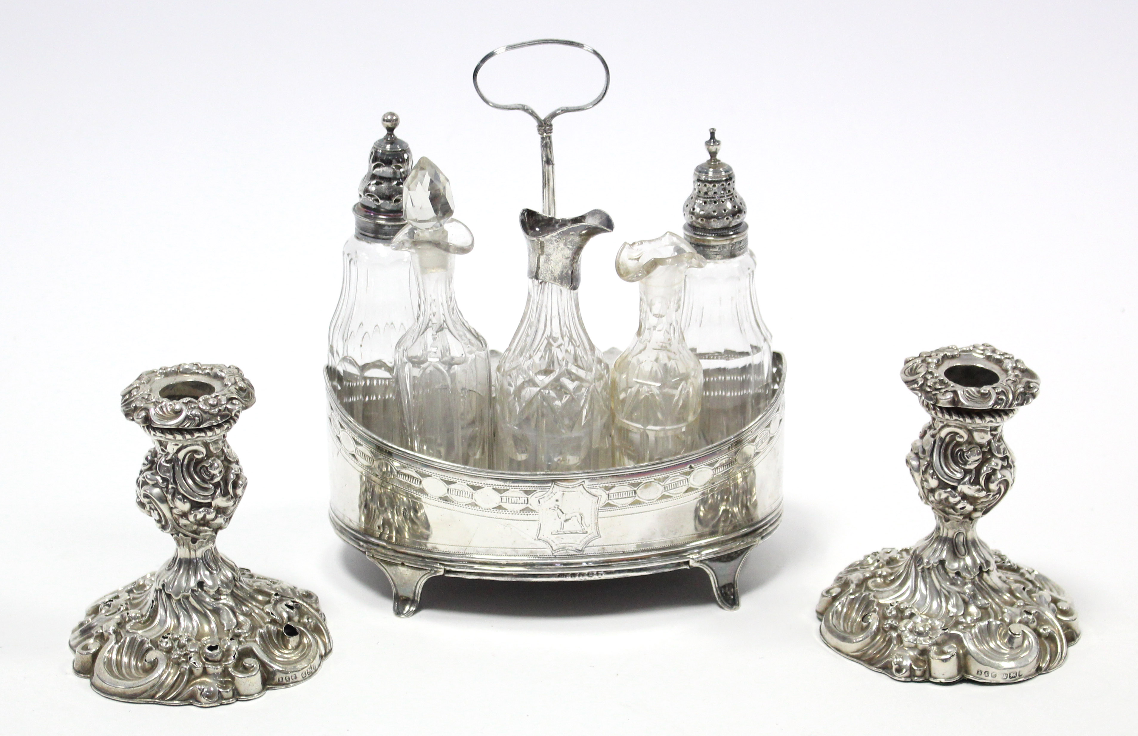 A George III silver oval cruet stand with centre ring handle, straight pierced sides, on four