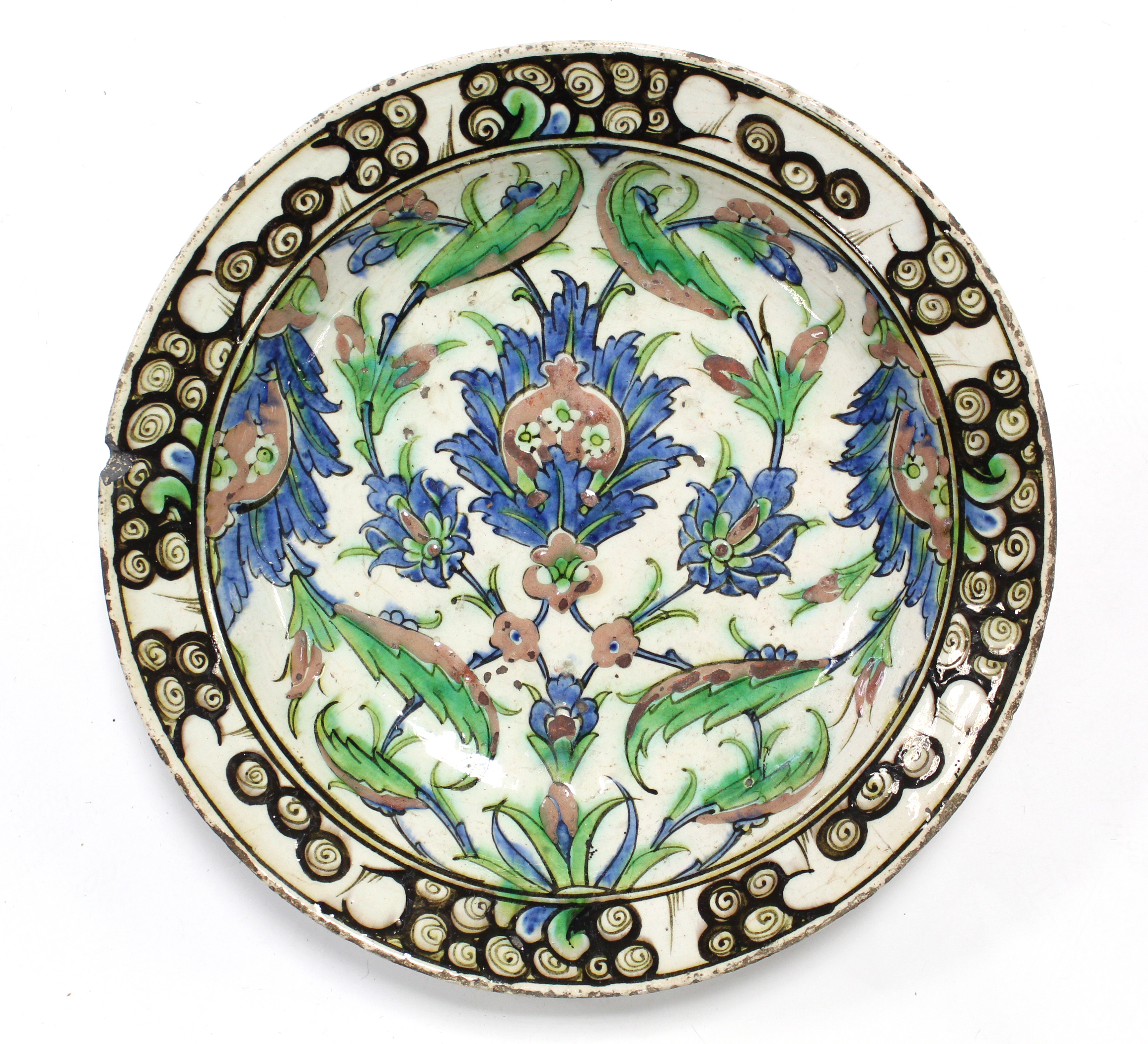 A 17th century IZNIK POTTERY SHALLOW DISH with polychrome painted stylised floral decoration