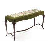 A Victorian long stool with padded seat upholstered floral needlework, on slender cabriole legs with