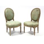A pair of Louis XVI style painted side chairs with round padded backs & seats upholstered pale-green