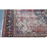 An antique Persian carpet of crimson, deep blue & ivory ground, with central medallion surrounded by