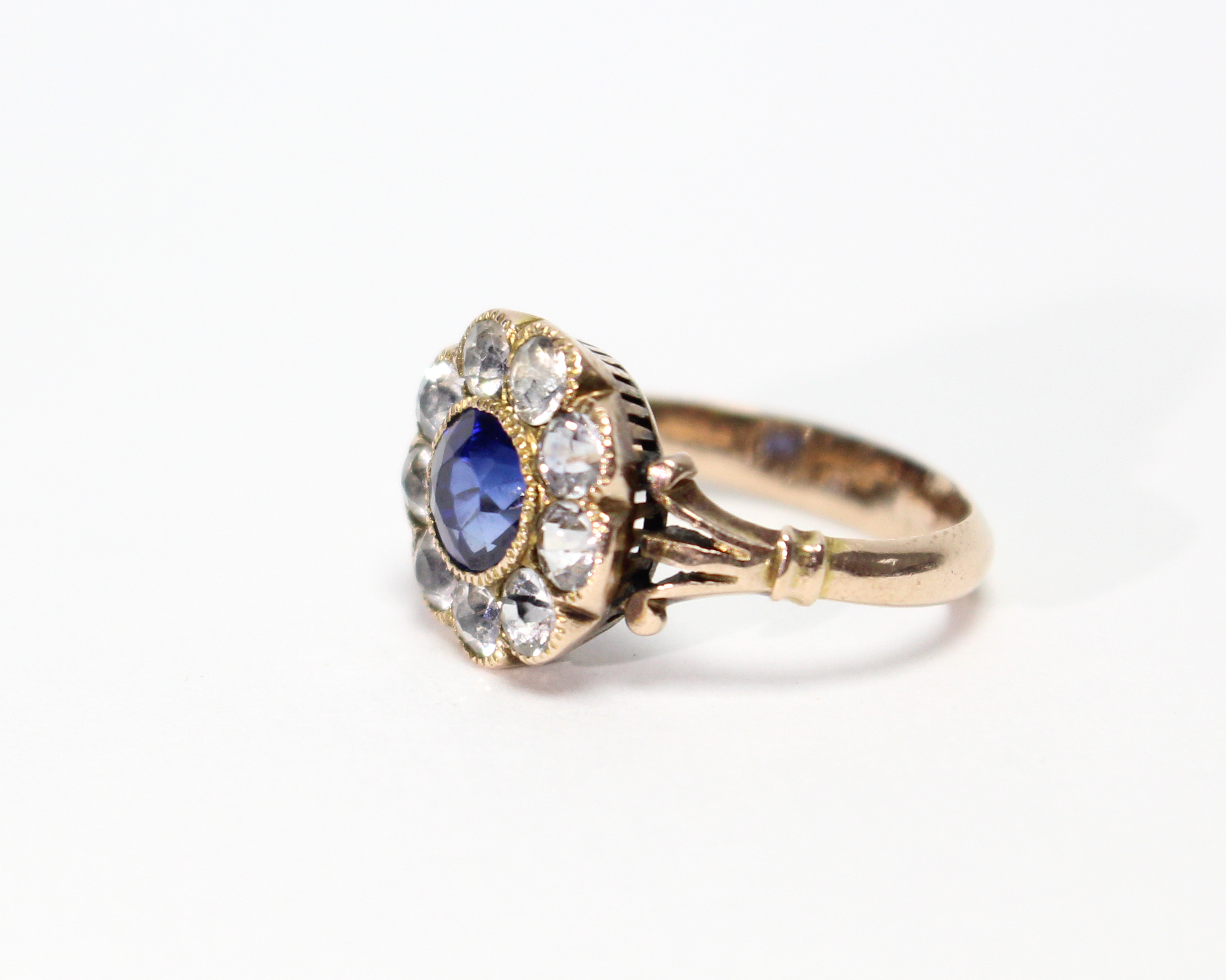 A late Victorian gold ring, millegrain-set with a round sapphire of approx. 0.75 carat within a - Image 2 of 3