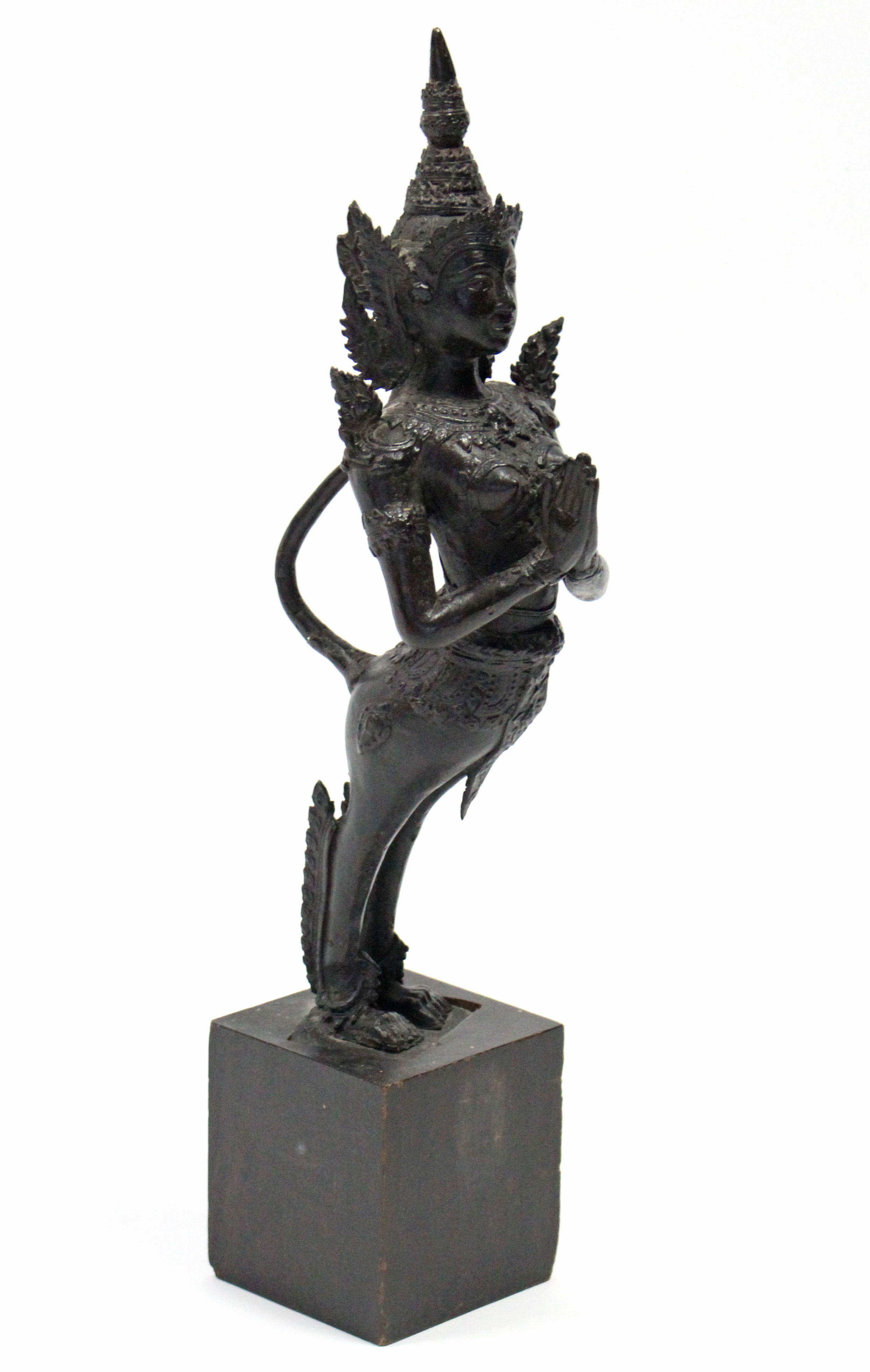 A Thai bronze standing figure of Kinnara with hands in prayer; 15¾” high, on wooden block base.