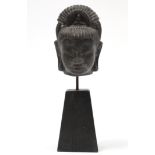 A Khmer carved stone head of a Buddhistic deity, 6½” high; mounted on wood block base.