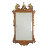 A GEORGE II RECTANGULAR WALL MIRROR in walnut veneered frame with fret-carved scroll border, gilt