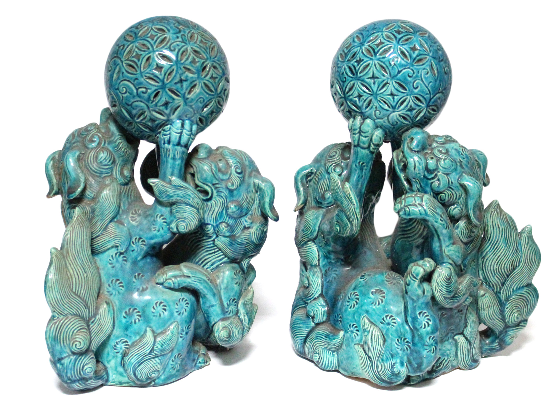 A pair of 19th century Chinese turquoise-glazed groups, each of two Kylin fighting over a brocaded