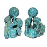 A pair of 19th century Chinese turquoise-glazed groups, each of two Kylin fighting over a brocaded