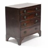 An early 19th century mahogany small chest fitted four long graduated drawers with oval brass