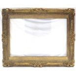 A large 19th century carved giltwood & gesso picture frame with shell & scroll decoration, 45” x 56”