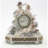 A Dresden porcelain mantel clock modelled with three cherubs, billing doves, & festoons of