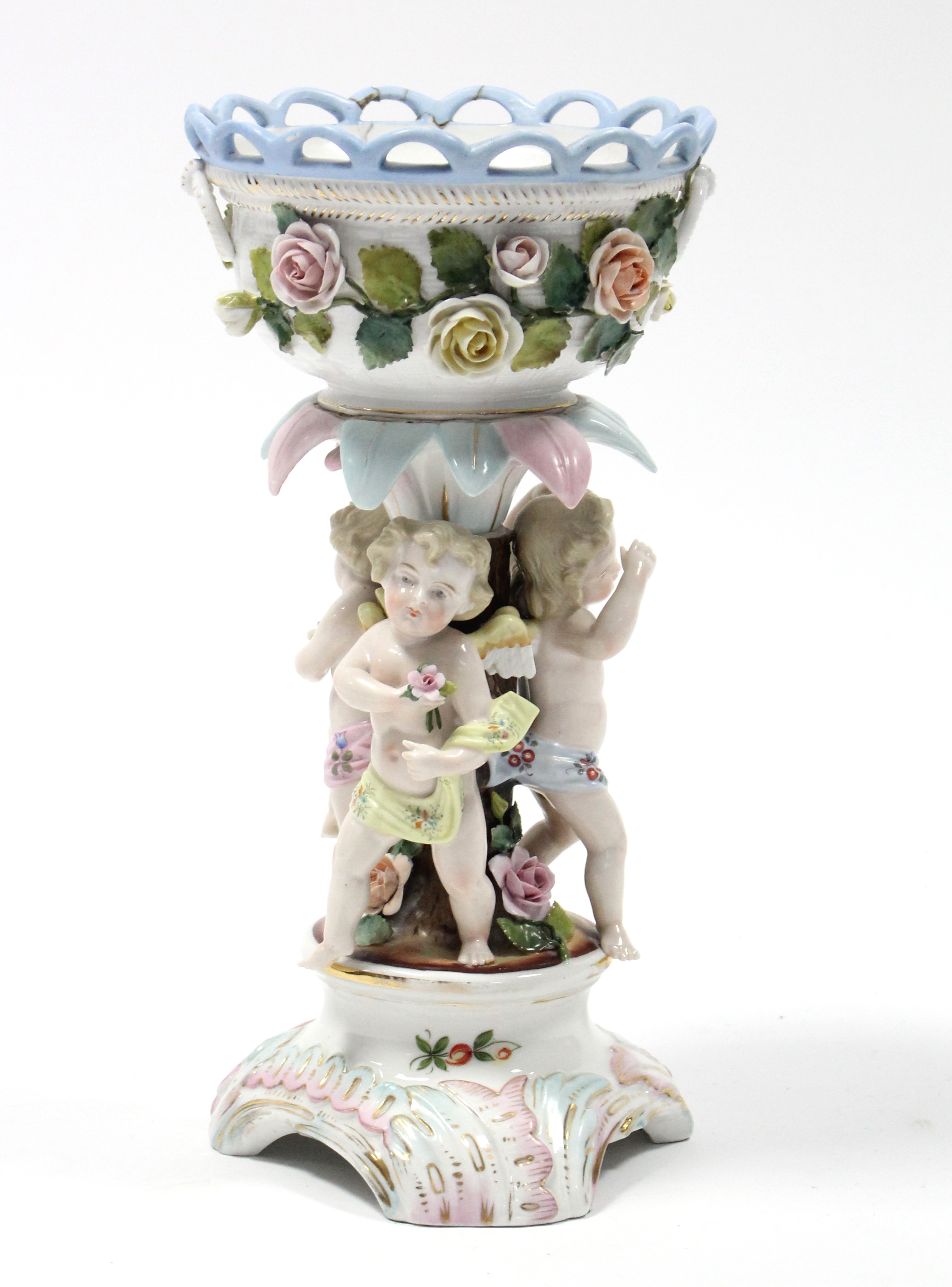 A Sitzendorf porcelain centrepiece with round floral-encrusted bowl supported by three cherubs, on