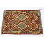 A vegetable-dye wool Kelim rug with multicoloured geometric lozenge design in hook border; 4’11 x