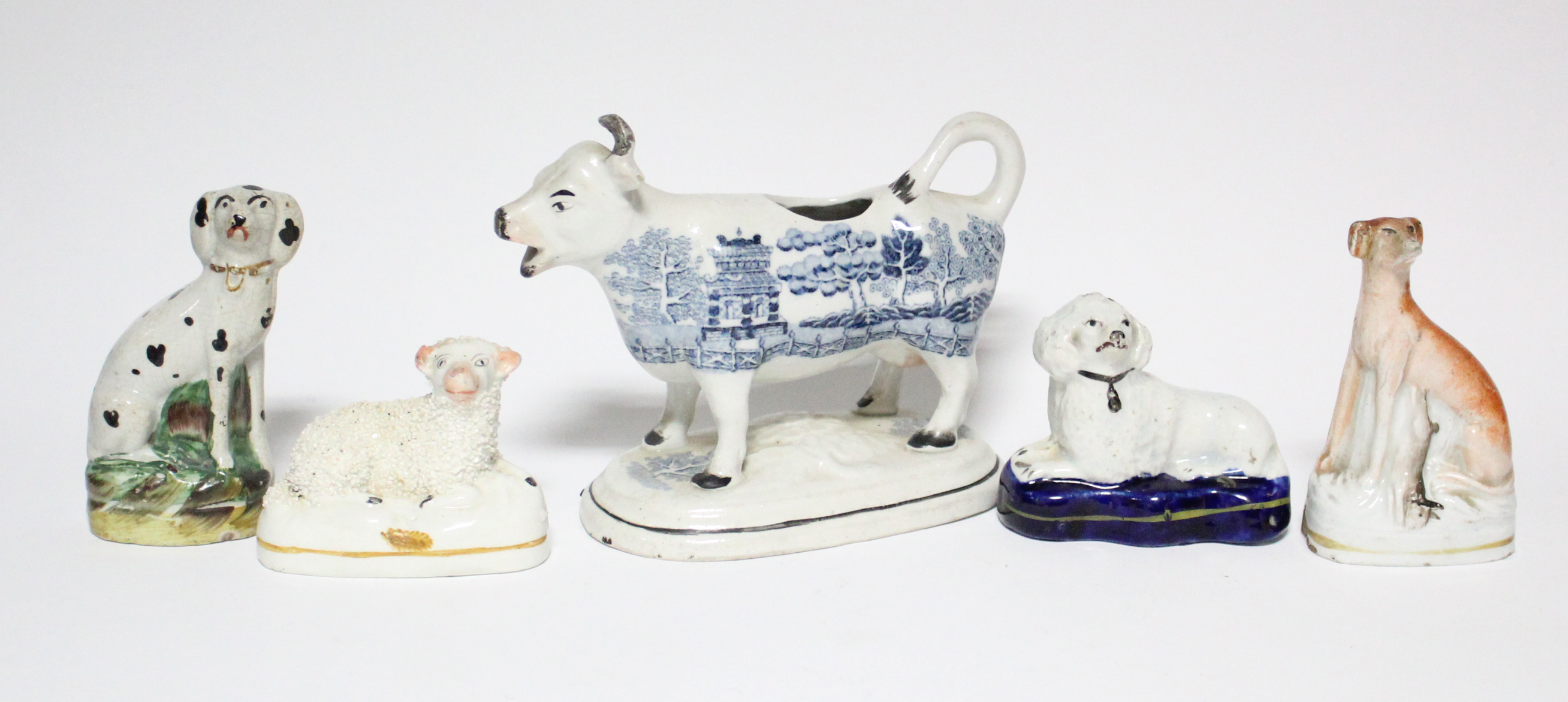 Three small Victorian Staffordshire pottery models of seated dogs, the largest 4” high; a ditto