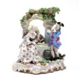 A Meissen porcelain group of male & female musician figures beside a stone arch, a boy bag-