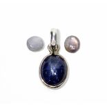 An oval blue star sapphire pendant; & two small un-mounted star sapphires in pink & white.