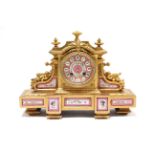A 19th century French mantel clock inset pink-ground porcelain plaques & dial with roman numerals,