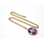 An oval-cut amethyst pendant in 9ct. gold mount, on yellow metal fine-link chain necklet.