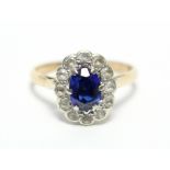 A 9ct. gold ring set oval synthetic sapphire within a border of small diamonds.