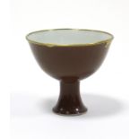 A Chinese porcelain stem cup with café-au-lait exterior, white interior, & with applied gilt-brass