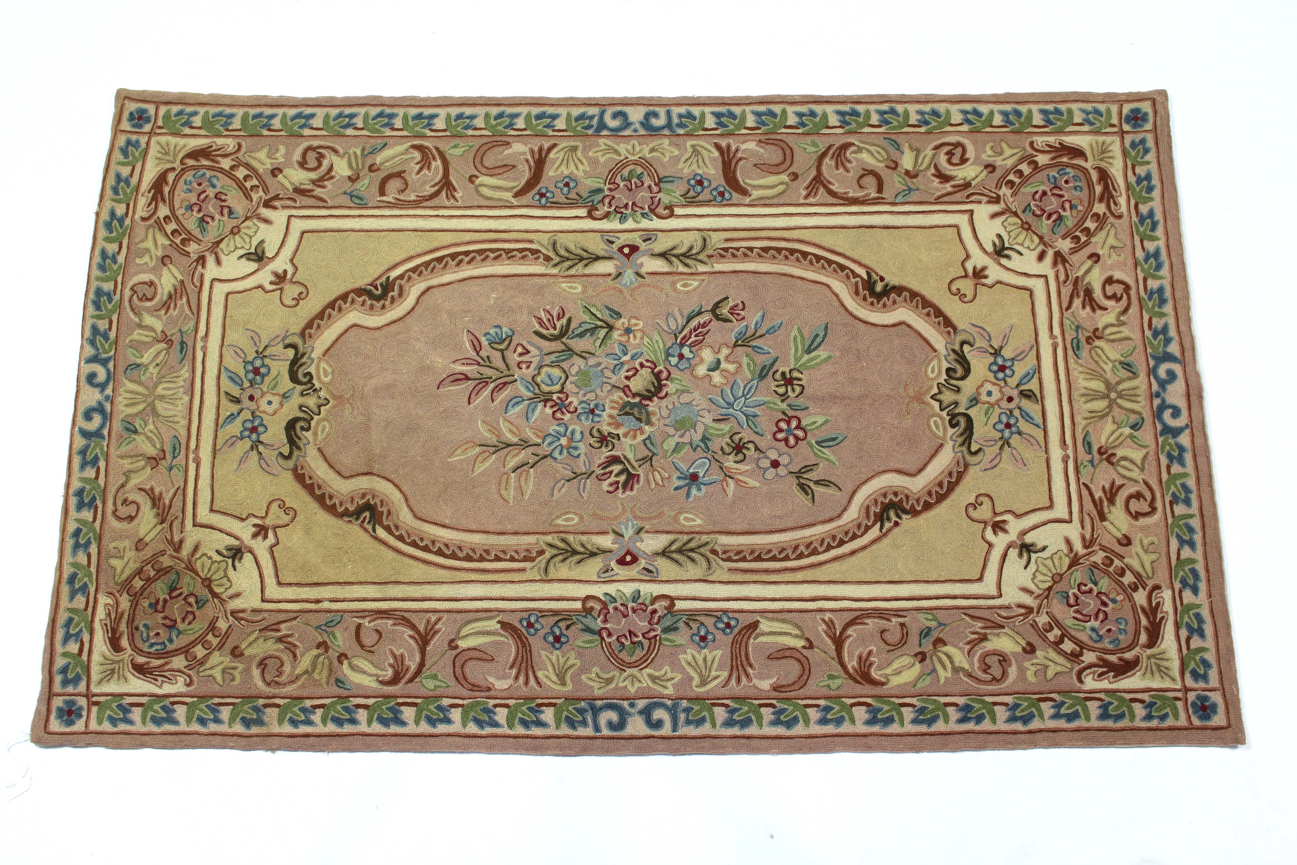 A Kashmiri hook-stitch rug of Aubusson design, cream & peach ground, with central reserve of flowers