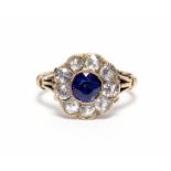 A late Victorian gold ring, millegrain-set with a round sapphire of approx. 0.75 carat within a