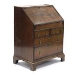 An 18th century oak bureau, the sloping fall-front enclosing a fitted interior with well