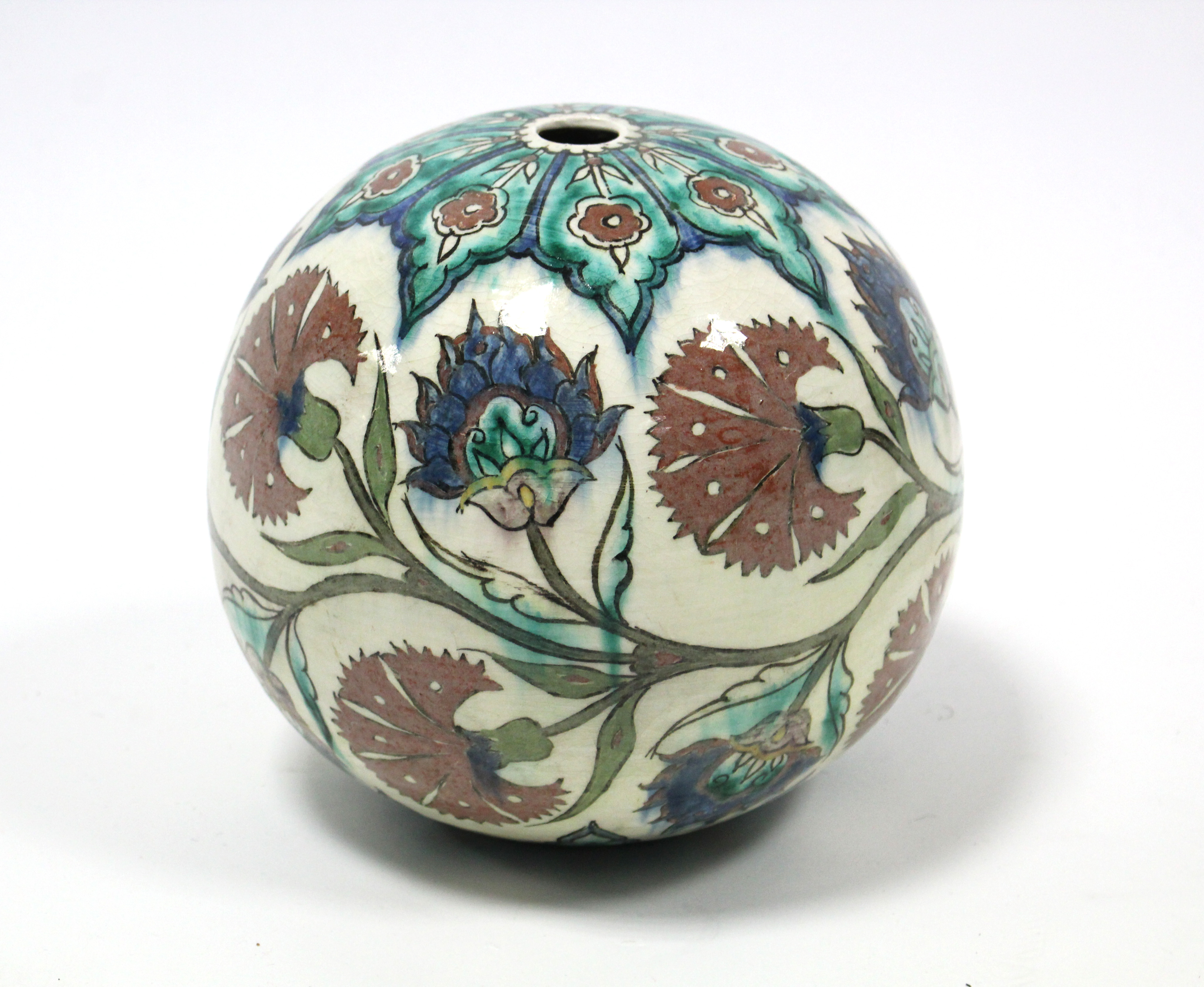 An Iznik-style pottery spherical pendant with painted floral decoration on a cream ground; 8” diam.