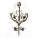 An Arts & Crafts style brass twin-branch wall light of scroll design, with fleur-de-lys finial &