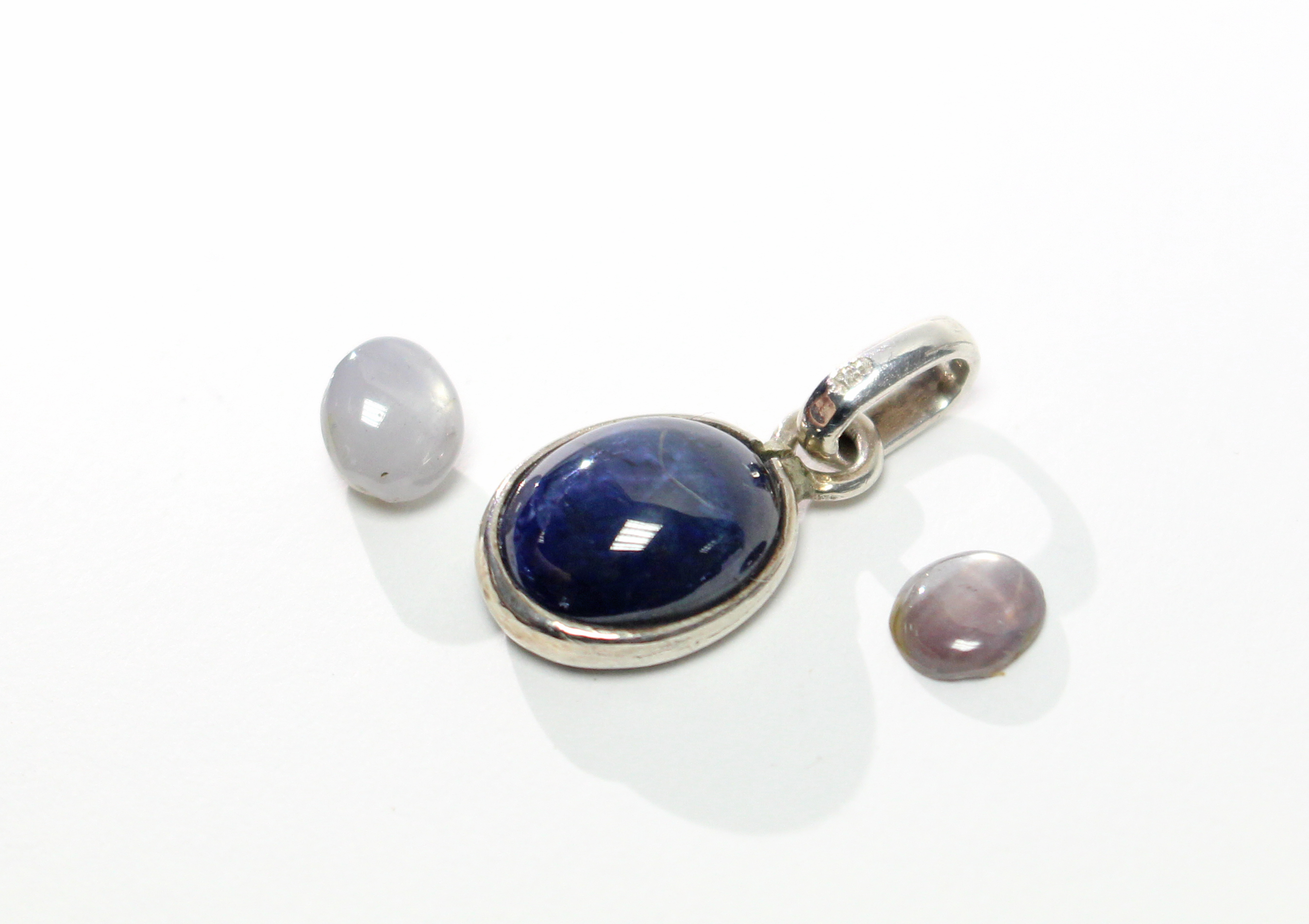 An oval blue star sapphire pendant; & two small un-mounted star sapphires in pink & white. - Image 2 of 2