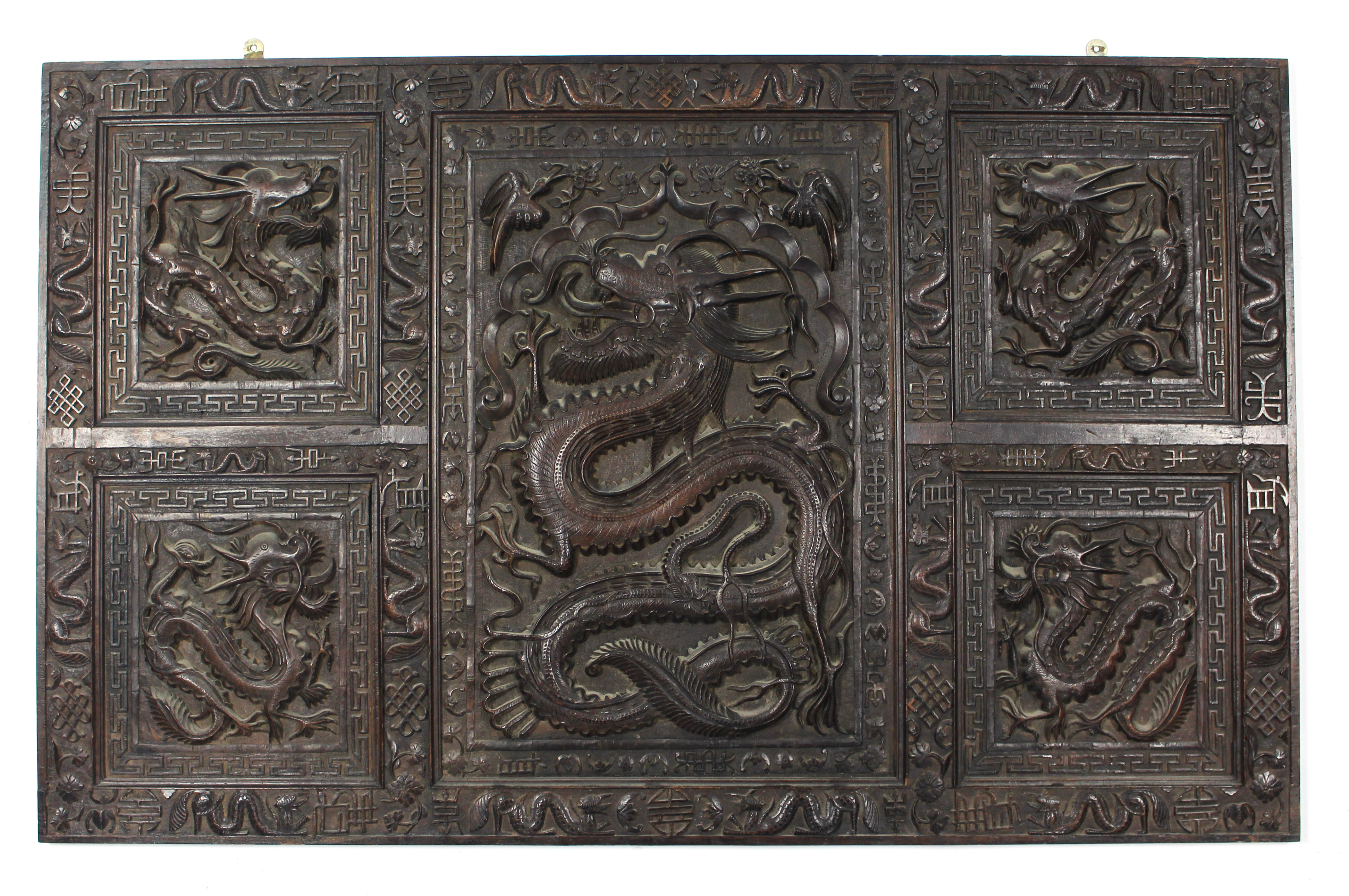 A late 19th/early 20th century Chinese carved hardwood panel with all-over decoration of dragons,