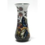 A Moorcroft pottery “Blackberry” vase of slender baluster form with flared rim, decorated with