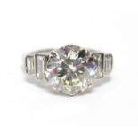 AN IMPRESSIVE DIAMOND RING, the brilliant-cut stone weighing approx. 3.5 carats, two graduated