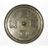 A Chinese archaistic bronze large circular mirror decorated with characters in low relief, a small